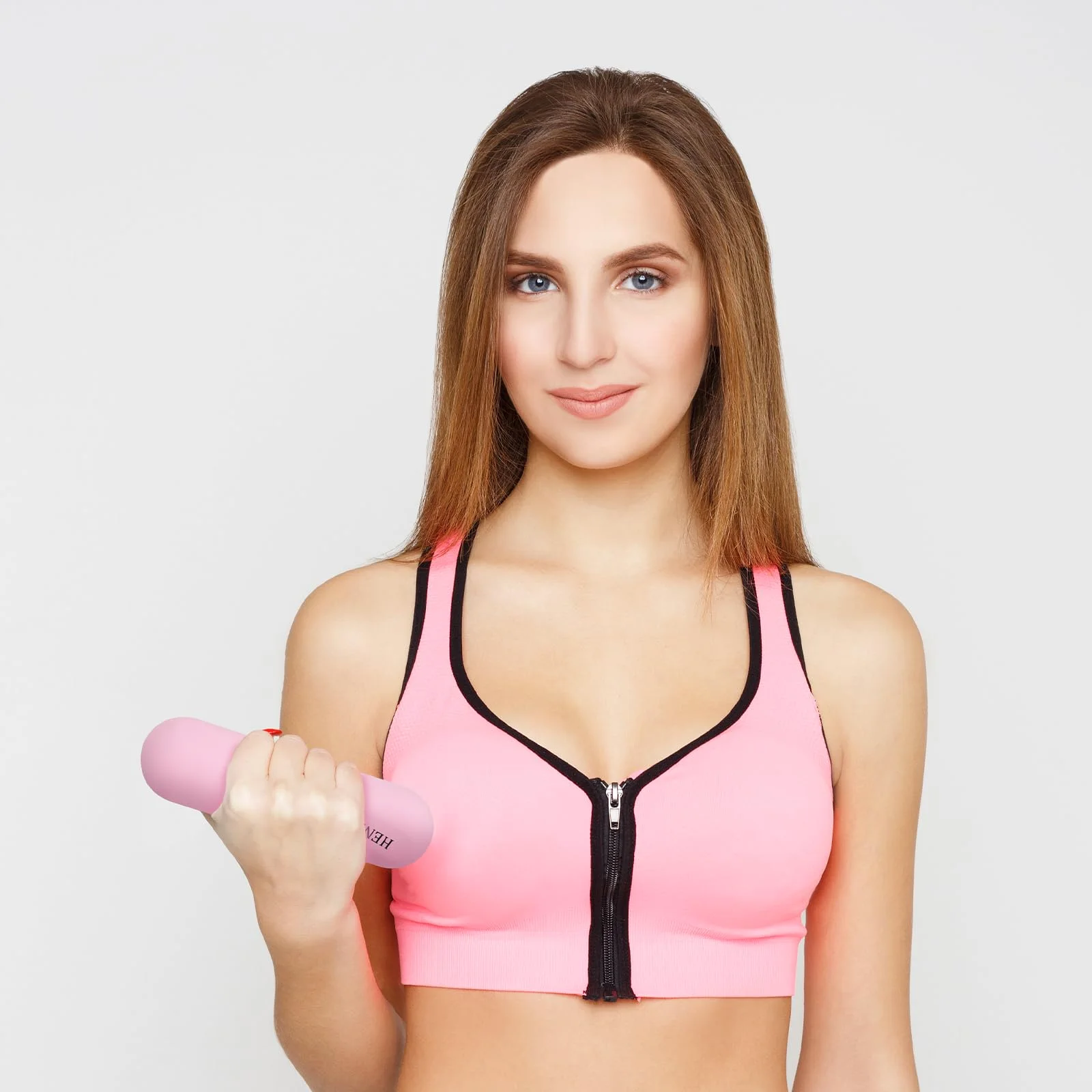 A woman holds a pink Henkelion silicone dumbbell